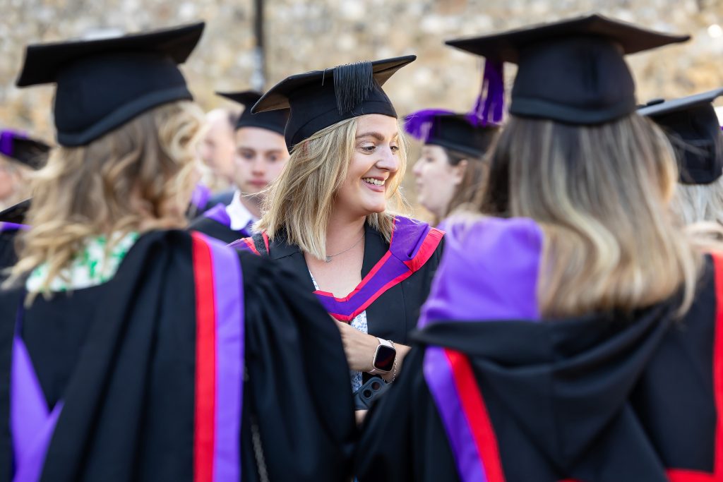 Graduates in academic gowns and caps gathered during University Centre Sparsholt graduation ceremony