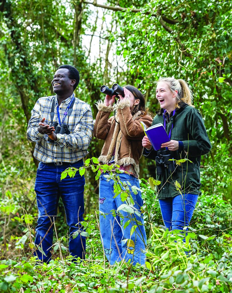 Students in UK woodland observing wildlife