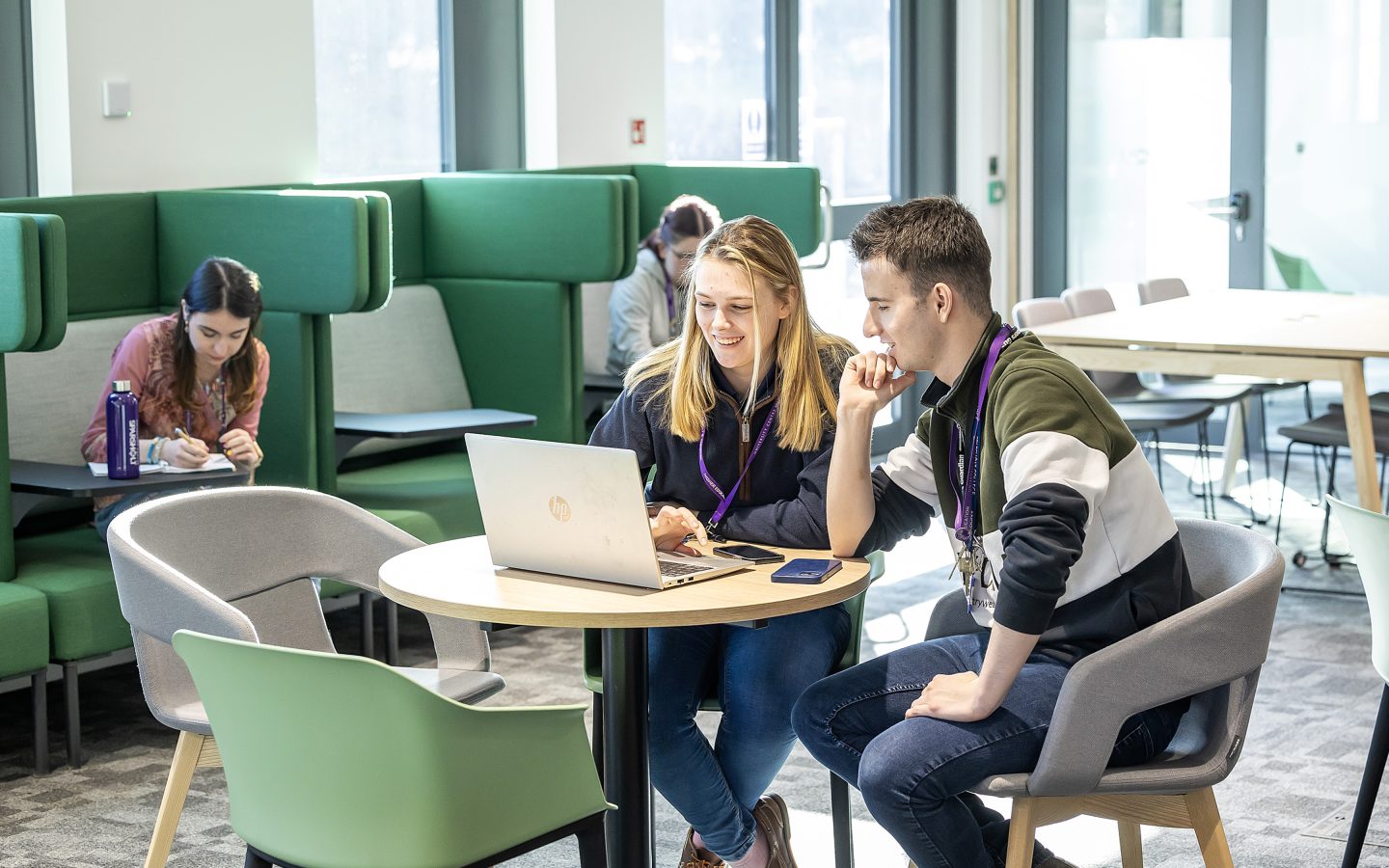 Students working together on a laptop in a bright and airy social space